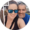 Smiling man and woman wearing sunglasses outdoors, close together.